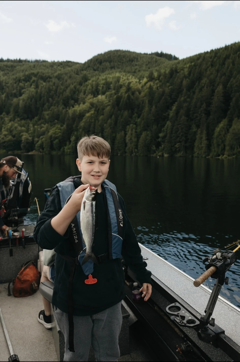 Young participant proudly holding a fish during PNW Provides Kids Fishing Day